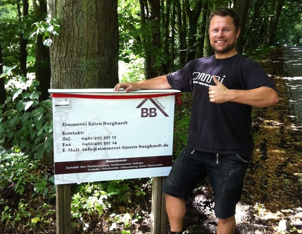 Björn Burghardt mit Firmenschild